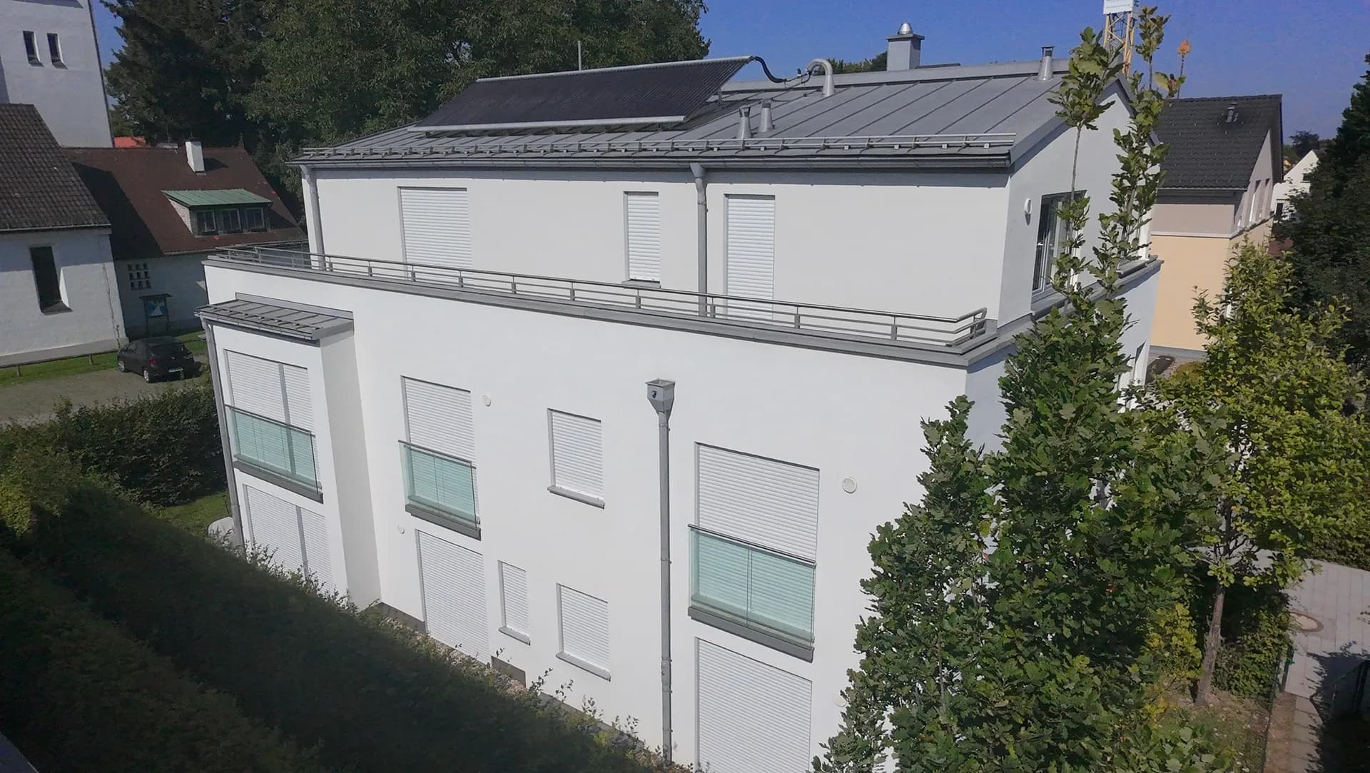 Modernes Mehrfamilienhaus mit Dachterrasse von oben