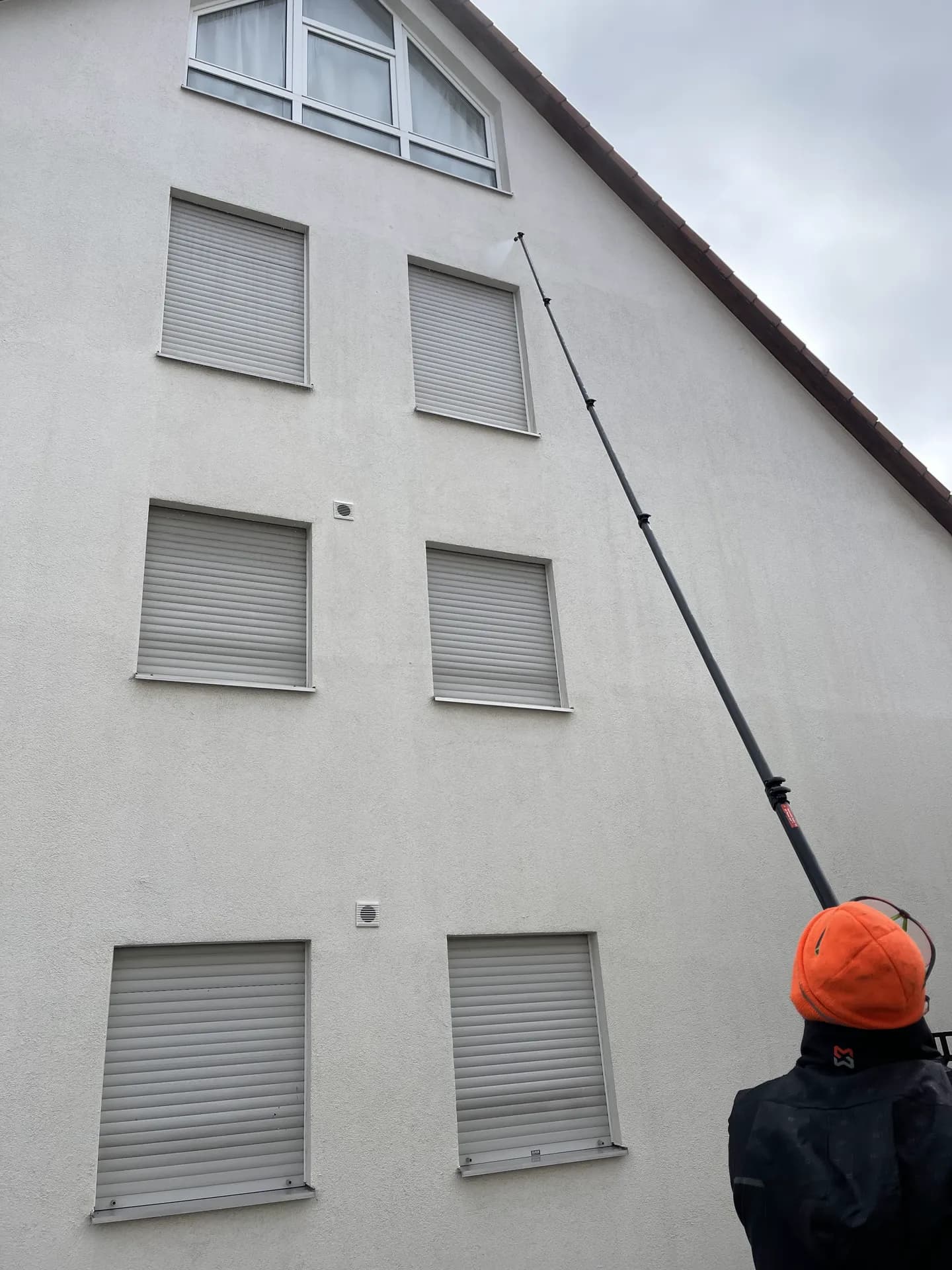 Teleskoplanze reinigt einen Hausgiebel